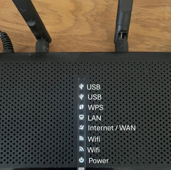 bild på en router där text är lagt för att visa vad routerns lampor betyder